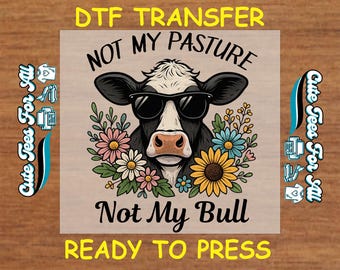 May include: DTF transfer design featuring a black and white cow wearing sunglasses, surrounded by flowers. Text reads "NOT MY PASTURE" and "NOT MY BULL". The words "READY TO PRESS" are also included.