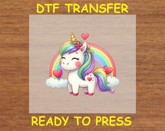 May include: A DTF transfer sheet with a cute cartoon unicorn with a rainbow and hearts. The sheet says "Ready to Press" at the bottom.