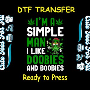 May include: Black DTF transfer with the text "I'M A SIMPLE MAN I LIKE DOOBIES AND BOOBIES" in white and green. A cartoon marijuana leaf character with a red hat and dreadlocks is in the center. The words "Ready to Press" are in yellow.