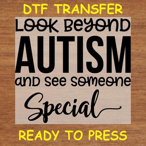 May include: A white sheet with black text that reads "DTG Transfer Look Beyond Autism and See Someone Special Ready To Press".