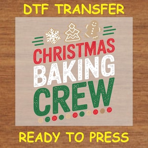 May include: A clear sheet with a green, red, and white design that says "Christmas Baking Crew" with a gingerbread man, a snowflake, and a Christmas tree. The sheet says "DTF Transfer Ready to Press" at the top and bottom.