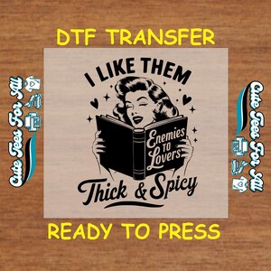 May include: A black and white graphic design featuring a woman reading a book with the text "I Like Them Enemies To Lovers Thick & Spicy" and the words "DTF Transfer Ready To Press".