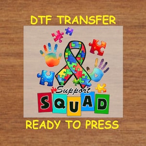 May include: A ready-to-press iron-on transfer design featuring a colorful puzzle piece ribbon, handprints, and the words "Support Squad".