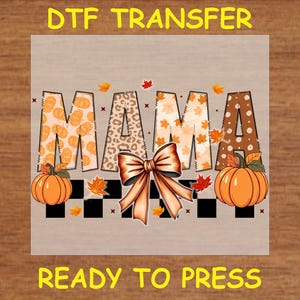 May include: A digital transfer design featuring the word "MAMA" in a fall-themed font with pumpkins, leaves, and a bow. The design is ready to press.