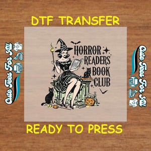 May include: DTF transfer featuring a vintage illustration of a witch reading a book, with a black cat, bats, and a jack-o'-lantern. The text reads "Horror Readers Book Club" and "Ready to Press."