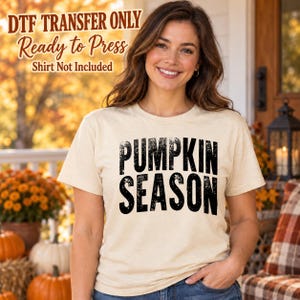 May include: A cream-colored short-sleeve t-shirt featuring the black text PUMPKIN SEASON in a distressed font. The image includes text overlays stating DTF TRANSFER ONLY, Ready to Press, and Shirt Not Included.