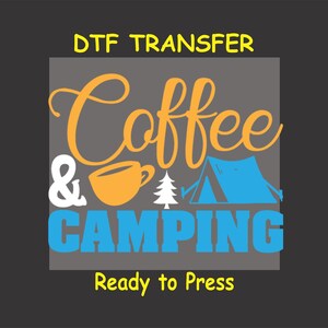 May include: A DTF transfer design featuring the text "Coffee & Camping" in orange and blue lettering. The design also includes a coffee cup, a pine tree, and a blue tent. The text "Ready to Press" is included below the design.