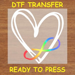 May include: A white heart with a rainbow infinity symbol inside. The design is on a clear transfer sheet, ready to be pressed onto a surface.