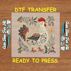 May include: A DTF transfer featuring a decorative hen design with floral and leaf accents. The hen is cream-colored with red, green, and brown details. Text includes "DTF TRANSFER", "Cute Tees For All", and "READY TO PRESS".