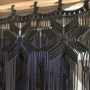Peut inclure: Suspension murale en macram&eacute; noir avec un motif g&eacute;om&eacute;trique. La suspension est faite de cordon de coton &eacute;pais et a une frange en bas.