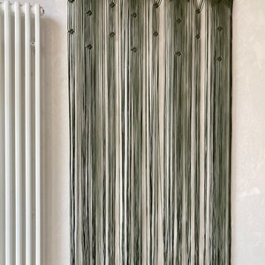 Peut inclure: Une suspension murale en macram&eacute; verte avec un motif d'&eacute;toile. La suspension est faite de plusieurs fils de laine et mesure environ 90 cm de haut.