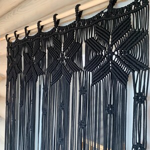 Peut inclure: Rideau en macram&eacute; noir avec un motif g&eacute;om&eacute;trique suspendu &agrave; une tringle en bois.