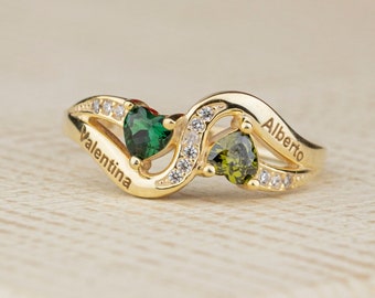 May include: Gold ring with two green heart-shaped gemstones and the names "Valentina" and "Alberto" engraved on the band.