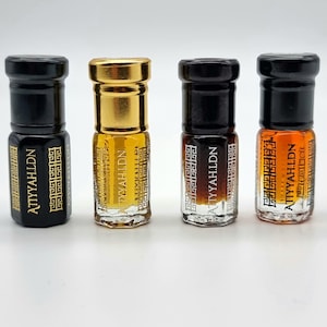 May include: Four small glass bottles with gold and black caps. Each bottle contains a brown liquid and has a gold label with the text "ATTYAHLDN" in a decorative font.