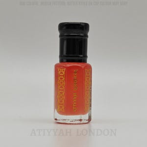 May include: A small, rectangular perfume bottle with a black cap and a vibrant orange body. The bottle features gold decorative accents and the text "ATTYYAH LONDON". The design suggests a fragrance product.