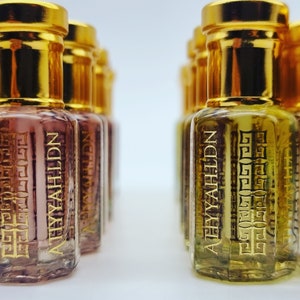 May include: A row of small, gold-capped glass bottles filled with a clear liquid. The bottles are labelled with the text "A'EYAHLDN" in a gold script.