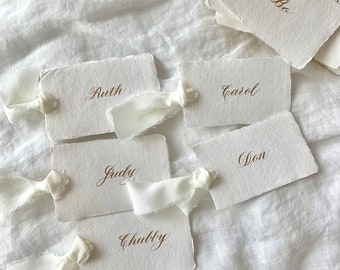 Marque-places en papier ivoire avec ruban soyeux blanc : cartes de visite avec bordure taupe, cartes de calligraphie en papier faites main, etc.