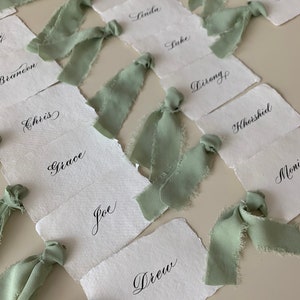 Tarjetas de lugar de color marfil con cinta de seda, tarjetas de nombre de boda blancas, tarjetas de papel con bordes desbarbados con caligrafía, tarjetas para platos de cena