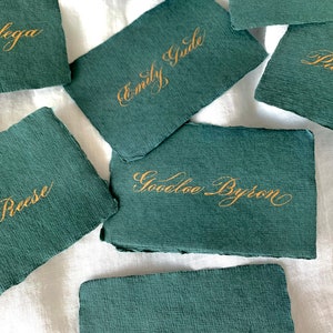 Carta da visita in carta verde scuro, etichetta per gli ospiti in calligrafia, carta di cotone con bordo frastagliato, piatto da portata vintage, scrittura con inchiostro dorato