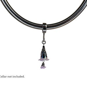 May include: A silver metal collar with a dangling charm featuring two white flower-shaped pendants with a black center.  The charm is attached to the collar with a silver ring.  *Collar not included.*