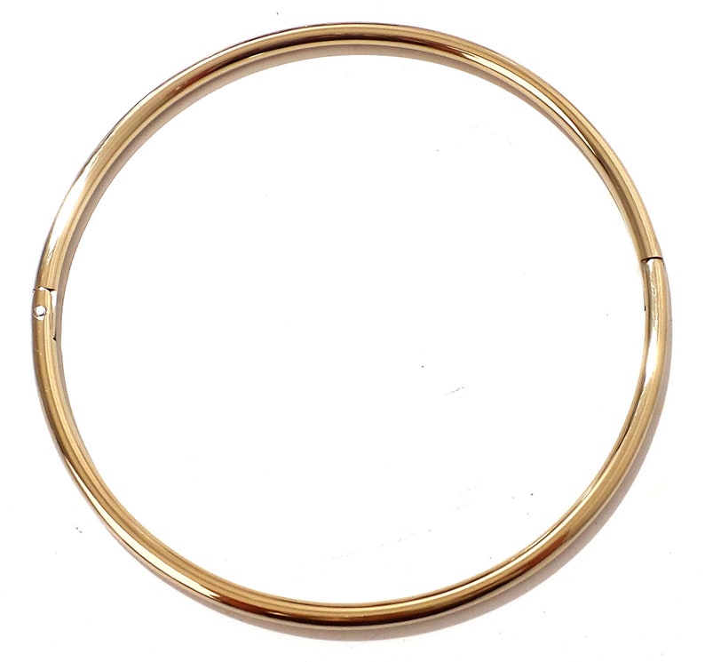 K&ouml;nnte beinhalten: Eine goldfarbene, kreisf&ouml;rmige Halskette mit einem Verschluss. Die Halskette ist ein schlichtes, elegantes Design, das f&uuml;r den t&auml;glichen Gebrauch geeignet ist. Das Metall hat eine polierte, reflektierende Oberfl&auml;che.