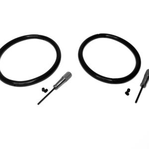 Puede incluir: Dos anillos de goma negra, dos pequeños tornillos negros y dos destornilladores plateados.