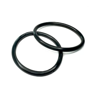May include: Two black metal rings, likely for attaching to a bag or purse.