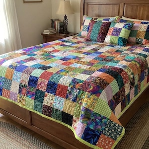 Könnte beinhalten: Ein Patchwork-Quilt mit einer lebendigen Mischung aus Farben und Mustern bedeckt ein Holzbett. Der Quilt zeigt Quadrate aus verschiedenen Stoffen in Blau-, Grün-, Rot- und Orangetönen. Passende Kissen ergänzen das Bettwäsche-Set.