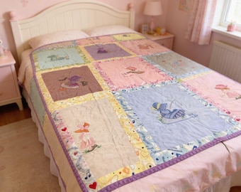 Puede incluir: Un edredón de retazos sobre una cama, con cuadrados bordados en colores pastel. El edredón tiene un borde morado y representa varias figuras. La cama está en una habitación rosa con un cabecero blanco.