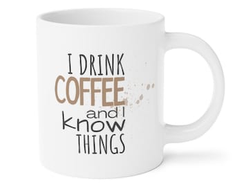 Op de afbeelding: Witte keramische koffiemok met de tekst "I drink coffee and I know things" in zwarte en bruine letters. De mok heeft bruine koffievlekken aan de zijkant.