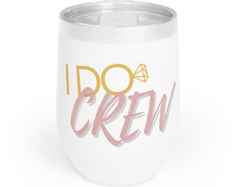 May include: White insulated wine tumbler with a silver rim and lid. The tumbler features the text "I DO CREW" in gold and pink, with a gold ring graphic. A stylish drinkware item for a bridal party.