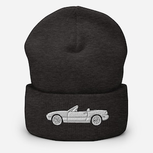 Puede incluir: Un gorro de lana gris oscuro con una imagen bordada en blanco de un coche descapotable.