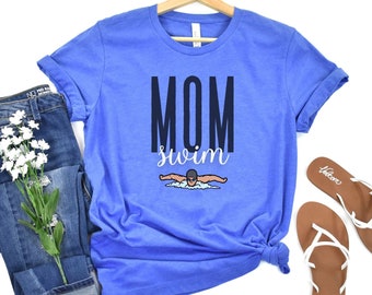 May include: A royal blue t-shirt with the text "MOM swim" in black and white. A cartoon swimmer is pictured in the center of the shirt.