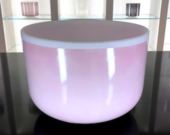 May include: A pink glass bowl with a white rim. The bowl has a smooth, glossy finish and a gradient effect, transitioning from a darker pink at the base to a lighter pink towards the top. The bowl is likely used for decorative or functional purposes.