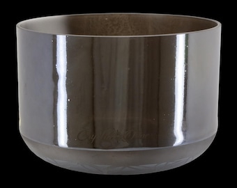 May include: A dark gray, cylindrical glass bowl with a wide opening. The bowl has a glossy finish and a slightly flared base with a decorative etched pattern. The text "Crystal Tones" is visible on the side.