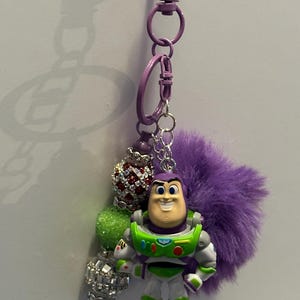 May include: A white ceramic mug with a black handle and the text "But First, Coffee" in a black, bold font. The mug is on a white surface.