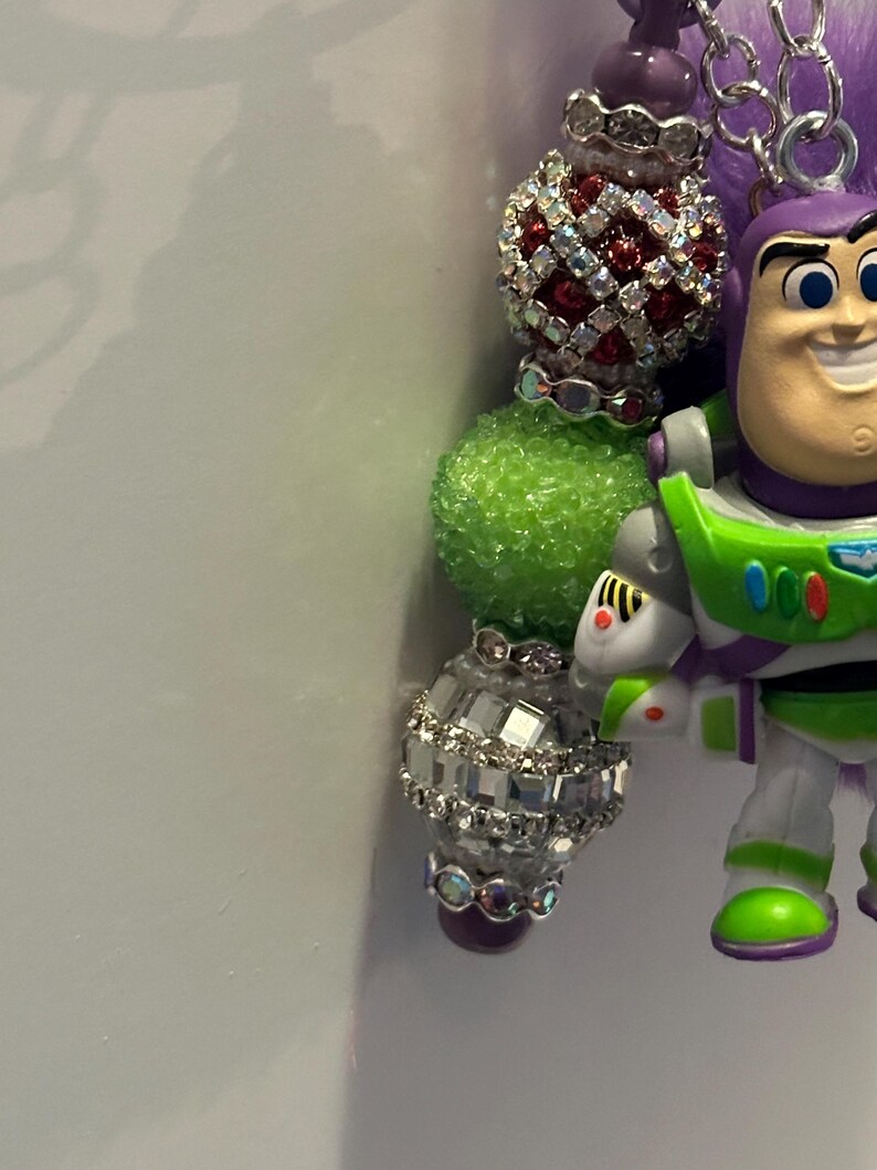 May include: A white ceramic mug with a black handle and the text "But First, Coffee" in a bold, black font. The mug is set against a blurred background, suggesting a cozy setting.