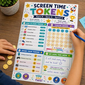 May include: A white reward chart titled Screen Time Tokens with sections for earning, banking, and spending tokens. The chart features colorful icons, a numbered grid from 1 to 30, and a goal section with handwritten text. Gold plastic coins are nearby.
