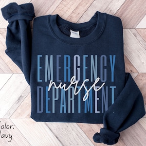 May include: Navy blue sweatshirt with the words "EMERGENCY nurse DEPARTMENT" in a gradient blue and white font. The sweatshirt is a crew neck style.
