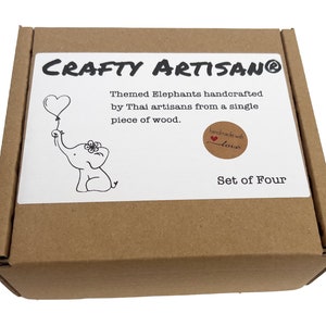May include: A brown cardboard box with a white label that says "CRAFTY ARTISANO&reg;" and "Themed Elephants handcrafted by Thai artisans from a single piece of wood. handmade with love Set of Four". The label has a black and white illustration of an elephant holding a heart-shaped balloon.