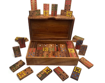 May include: A wooden box filled with colorful dominoes. The dominoes have red, yellow, blue, and green dots. The box is made of dark wood and has a hinged lid.