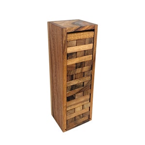 Op de afbeelding: Een houten blokkenstapelspel met een toren van blokken in een houten doos. De blokken zijn gemaakt van natuurlijk hout in een bruine en roodbruine kleur.
