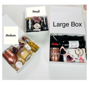 May include: Three gift boxes in different sizes, labeled "Small", "Medium", and "Large Box". Each box is filled with various gifts, including a bottle of wine, a candle, a tumbler, and sunglasses.