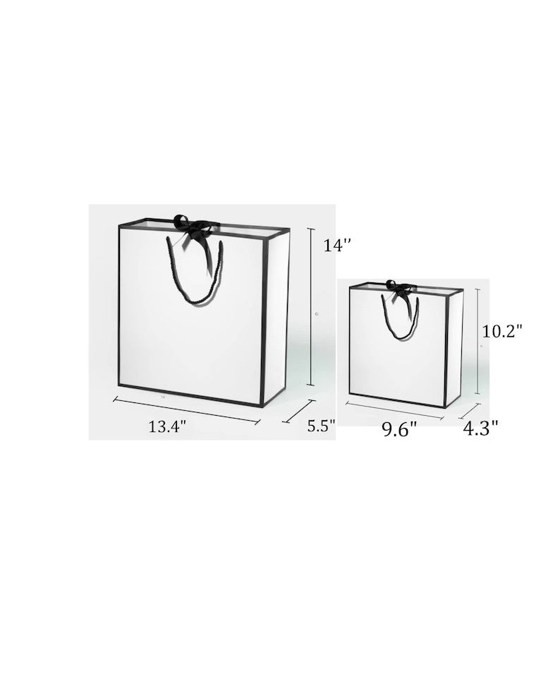 K&ouml;nnte beinhalten: Zwei wei&szlig;e Geschenkt&uuml;ten mit schwarzen Schleifenb&auml;ndern und schwarzem Besatz. Die gr&ouml;&szlig;ere Tasche misst 13,4 Zoll breit, 14 Zoll hoch und 5,5 Zoll tief. Die kleinere Tasche misst 9,6 Zoll breit, 10,2 Zoll hoch und 4,3 Zoll tief.