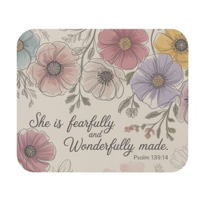 May include: Square coaster featuring a floral design with pastel pink, purple, yellow, and blue flowers. The text "She is fearfully and wonderfully made. Psalm 139:14" is printed on the coaster.