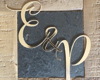 May include: Gold cursive letters "E & P" on a black slate background.