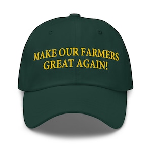 May include: A dark green baseball cap with the embroidered text "MAKE OUR FARMERS GREAT AGAIN!" in yellow. The cap has a curved brim and a button on top.