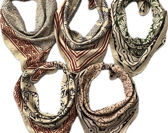 May include: Five cotton bandanas with different patterns. Each bandana is a square with a red, white, and black border. The bandanas have a variety of patterns, including floral, geometric, and paisley.