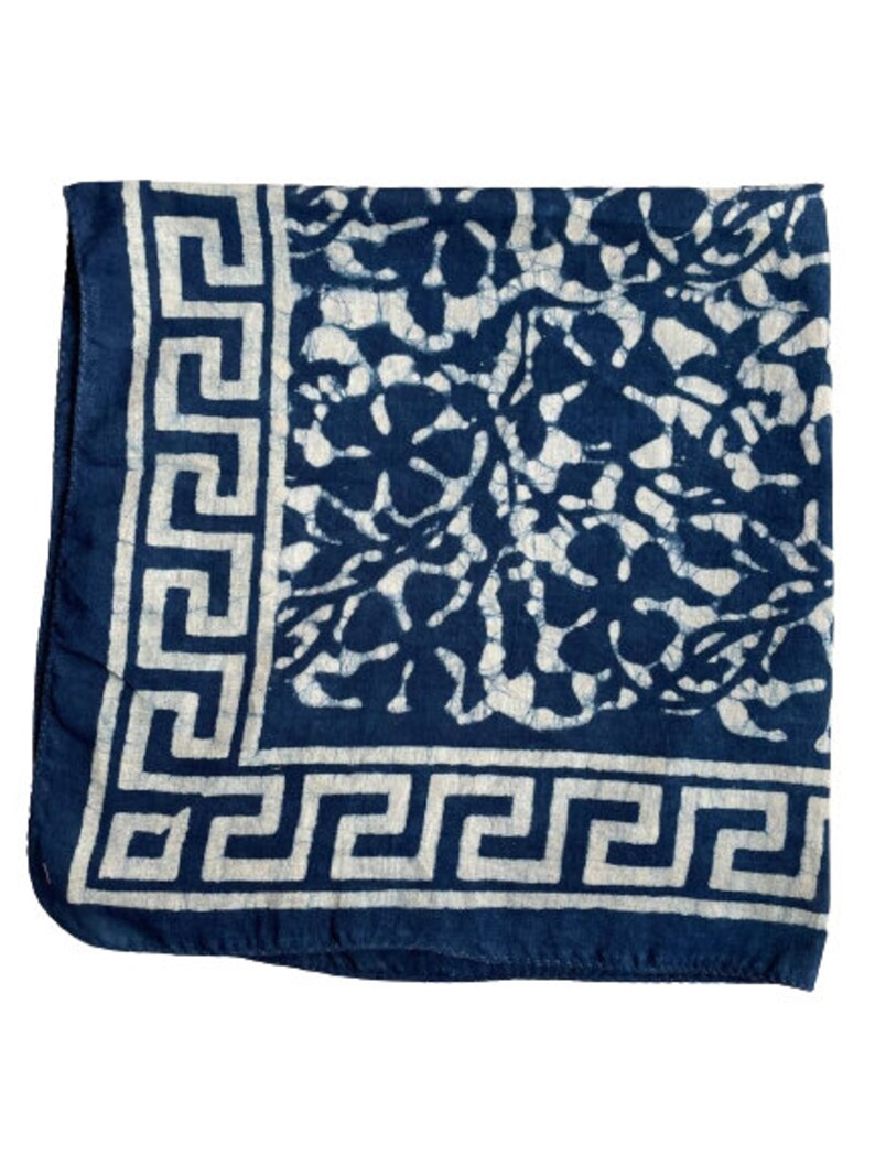 May include: A blue and white cotton bandana with a floral pattern and a white greek key border.