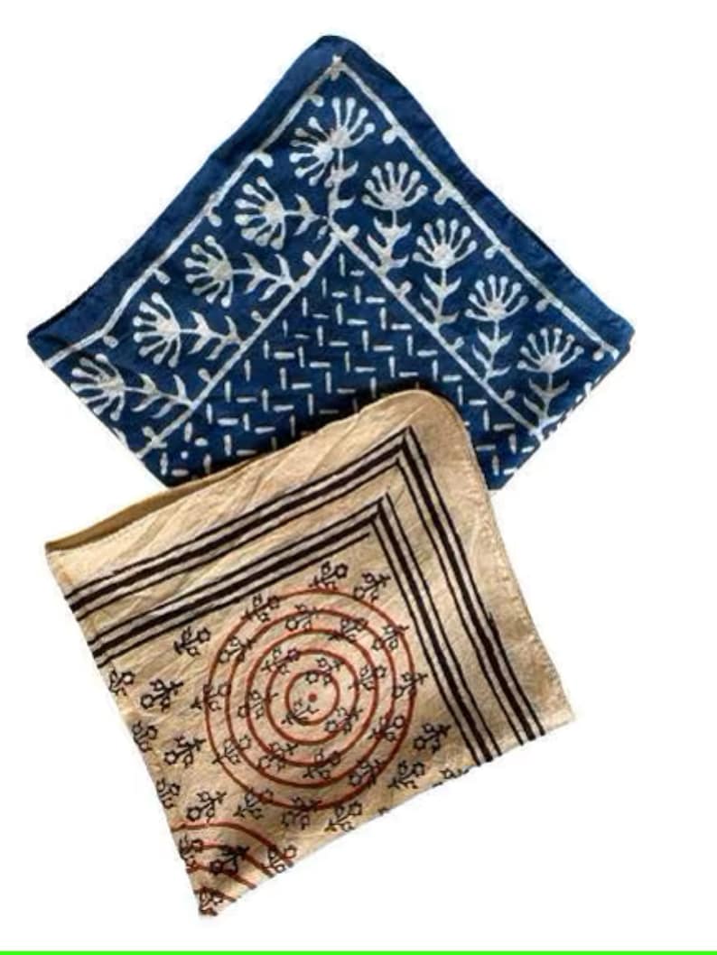 May include: Two cotton bandanas, one blue with a white floral pattern and the other beige with a black and red circular pattern.